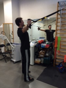 Entrenador de TRX mostrando ejercicios para la Recuperación de hombro mediante ejercicios de TRX.  