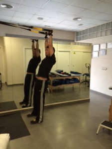 Entrenador de TRX mostrando ejercicios para la Recuperación de hombro mediante ejercicios de TRX.  